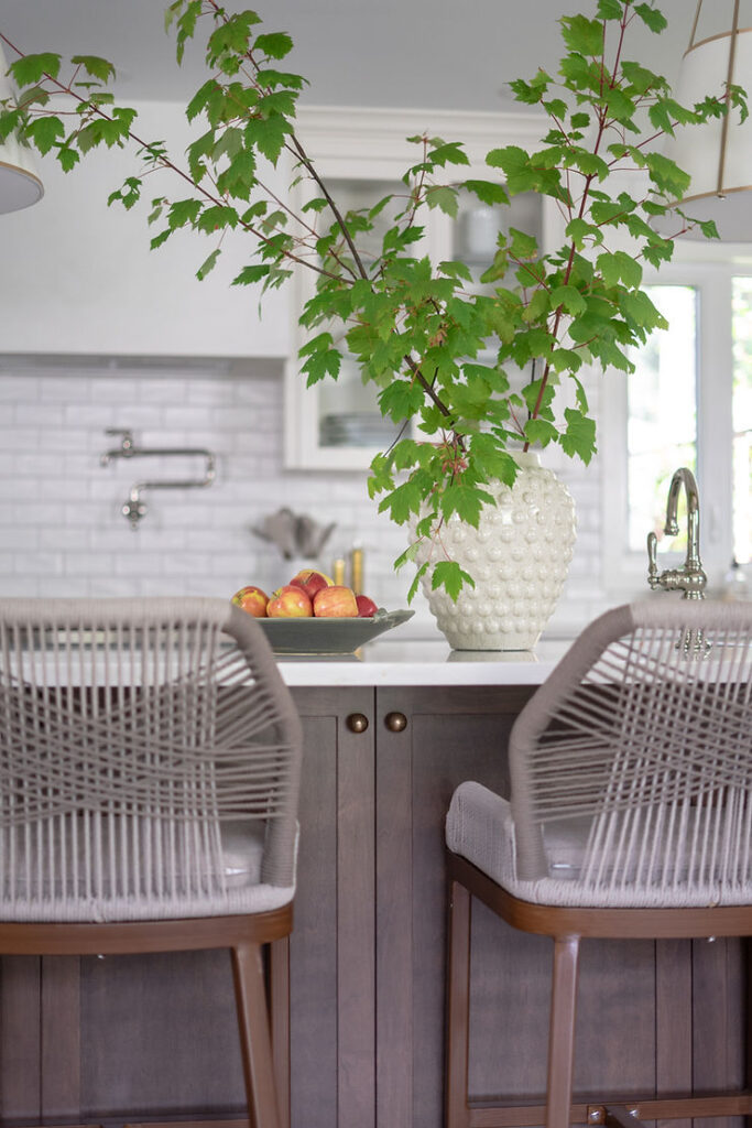 transitional cream kitchen with stained island and rope bar stools