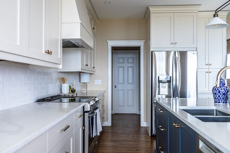 Transitional cream kitchen with navy island, modern island light