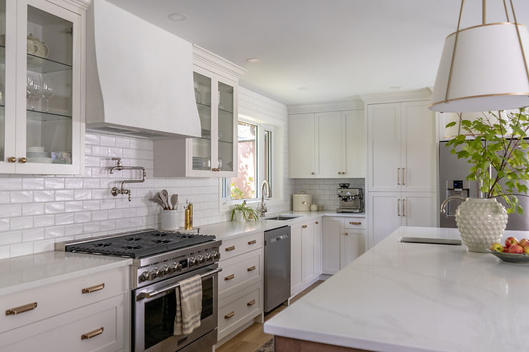 transitional cream kitchen with plaster hood fan glass cabinetry
