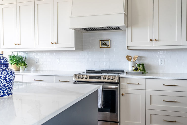 Transitional cream kitchen with navy island artwork above stove