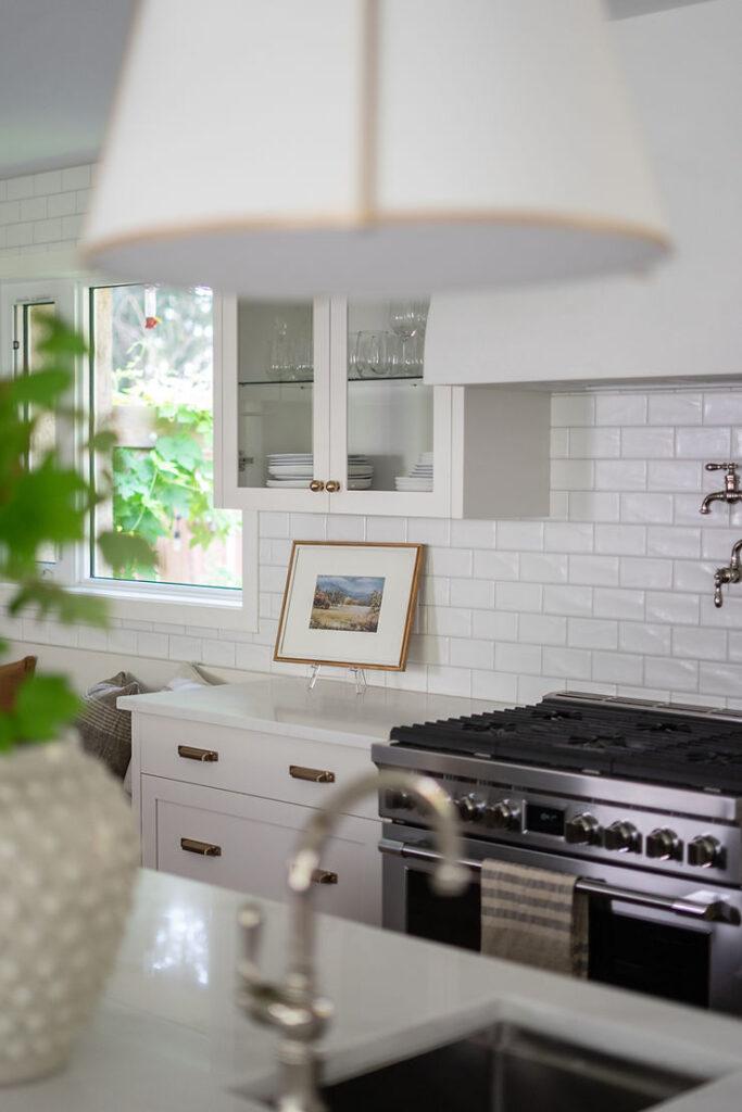 transitional cream kitchen with plaster hood fan glass cabinetry