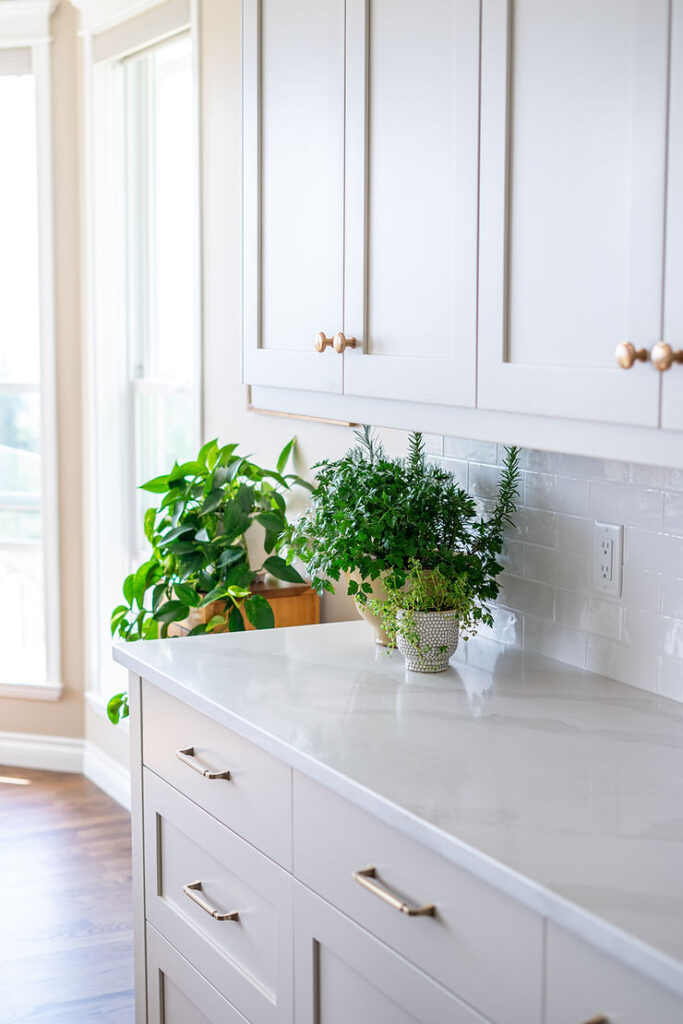 Transitional cream kitchen with navy island, modern island light