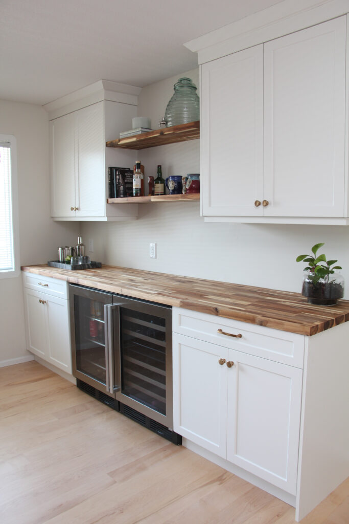 bar in dining room, white cabinets, butcher block countertop, floating wood shelves