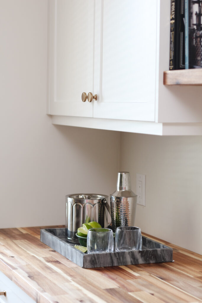 bar in dining room, white cabinets, butcher block countertop, floating wood shelves
