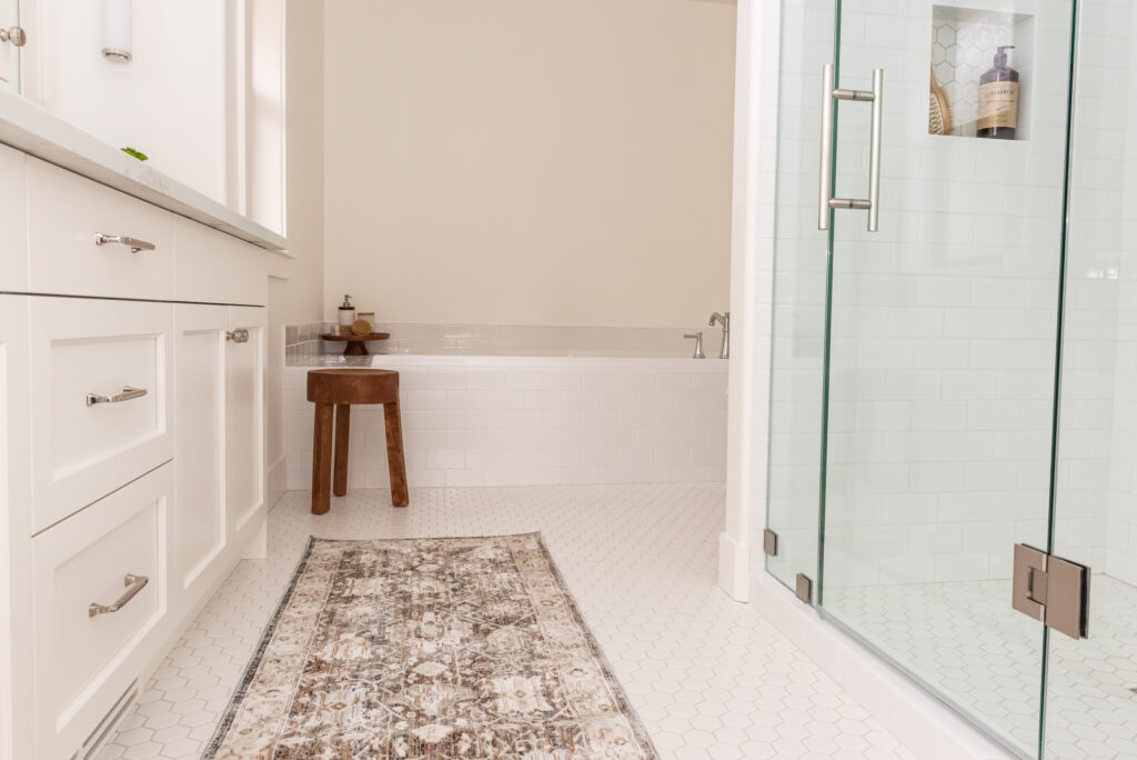 Warm white bathroom with rug and stool