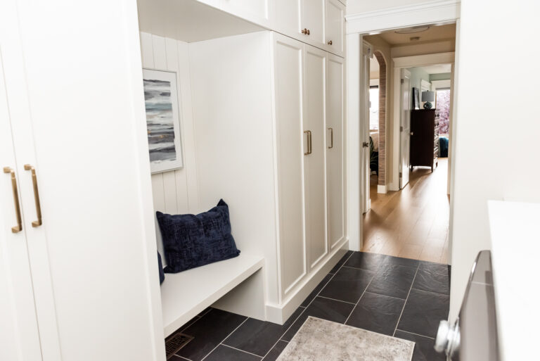 Cream mudroom cabinetry shiplap seating nook