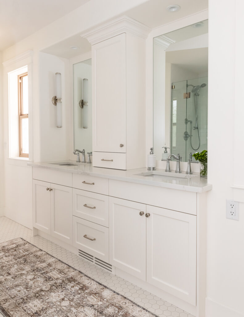 Traditional white vanity with linen tower and crown moulding