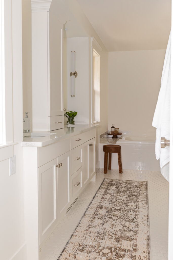 Traditional white vanity with linen tower and crown moulding