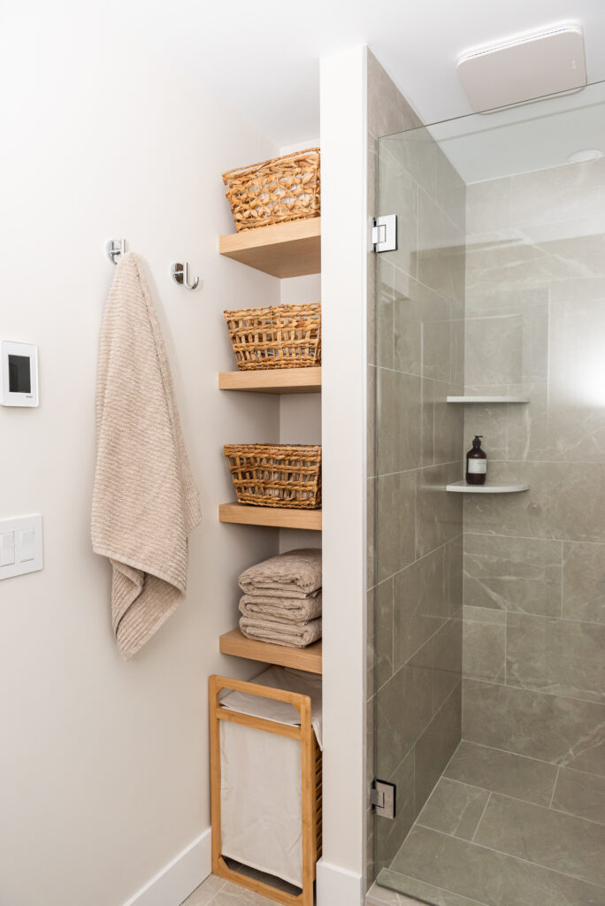 basement bathroom with open shelving and walk in shower