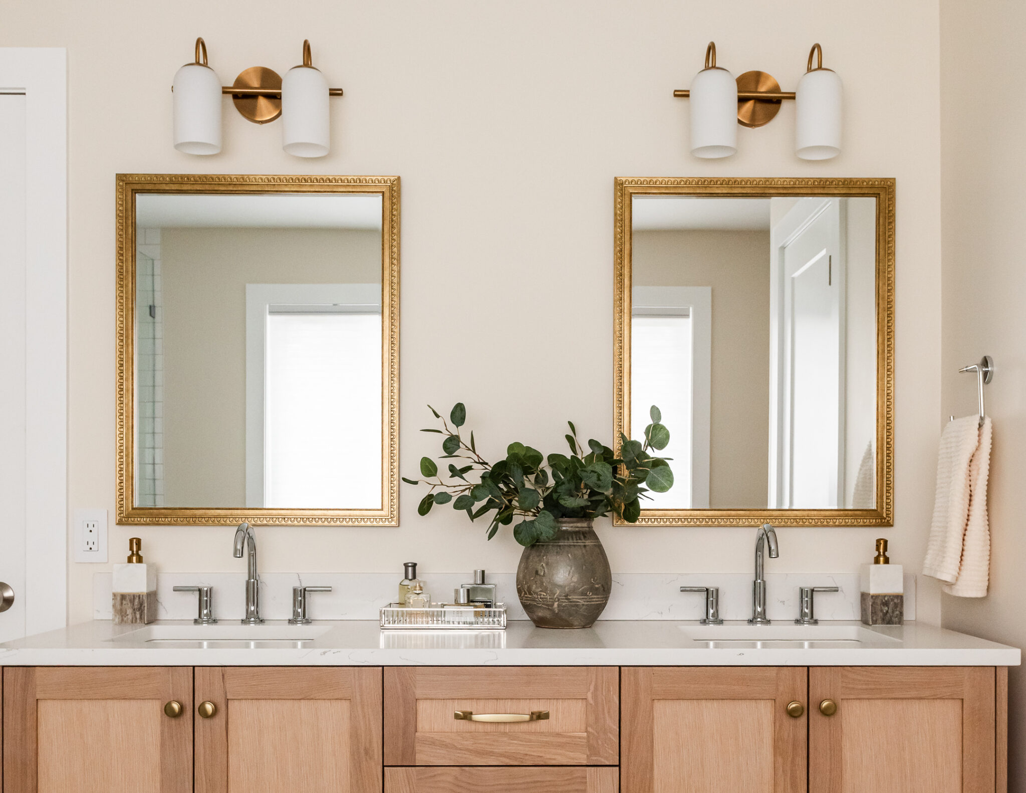 transitional ensuite with white oak vanity, vintage mirrors and styling