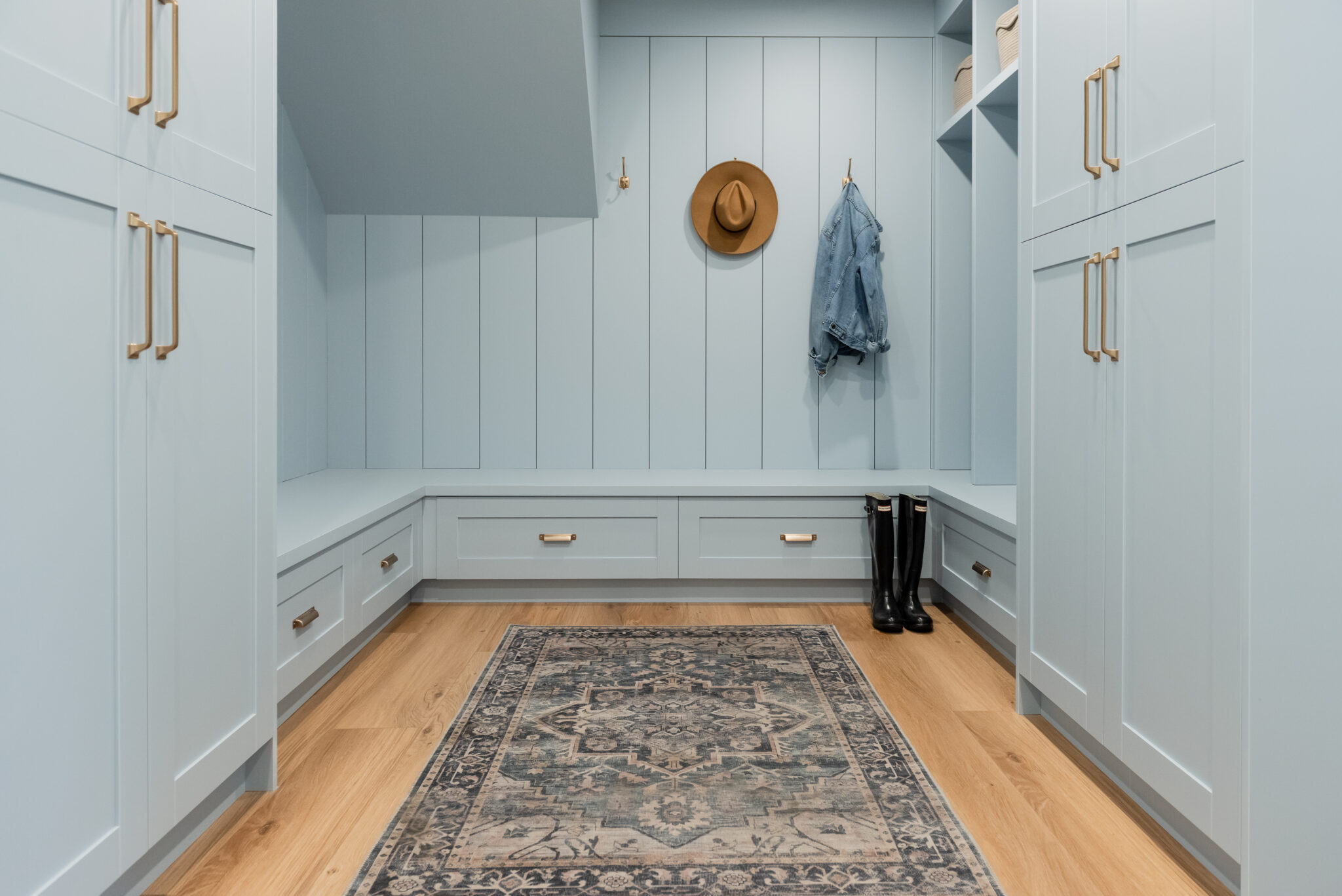 blue mudroom with gold hardware and shiplap