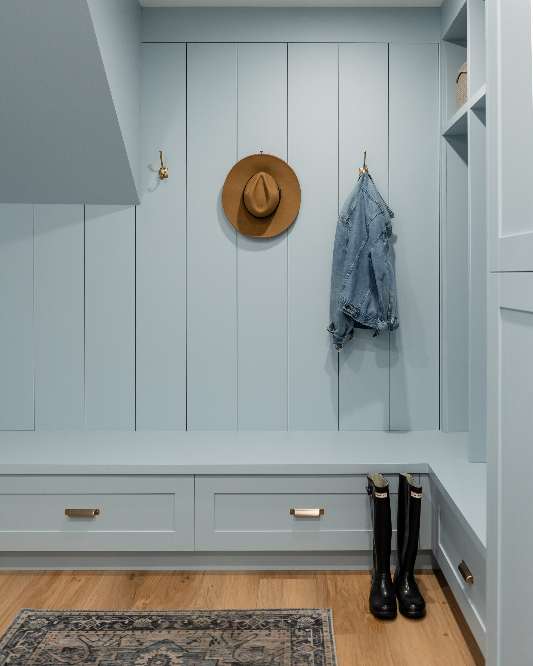 blue mudroom with gold hardware and shiplap