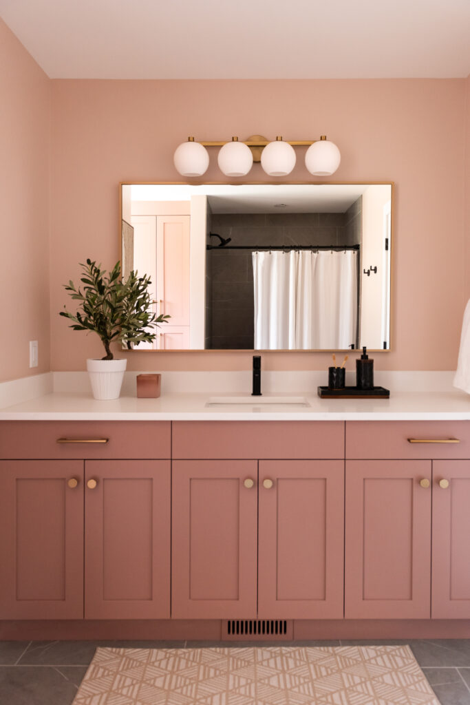pink bathroom with gold and black accents