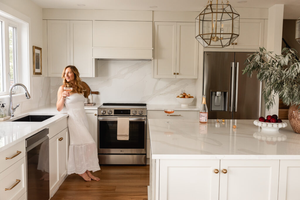 woman drinking champagne in white kitchen