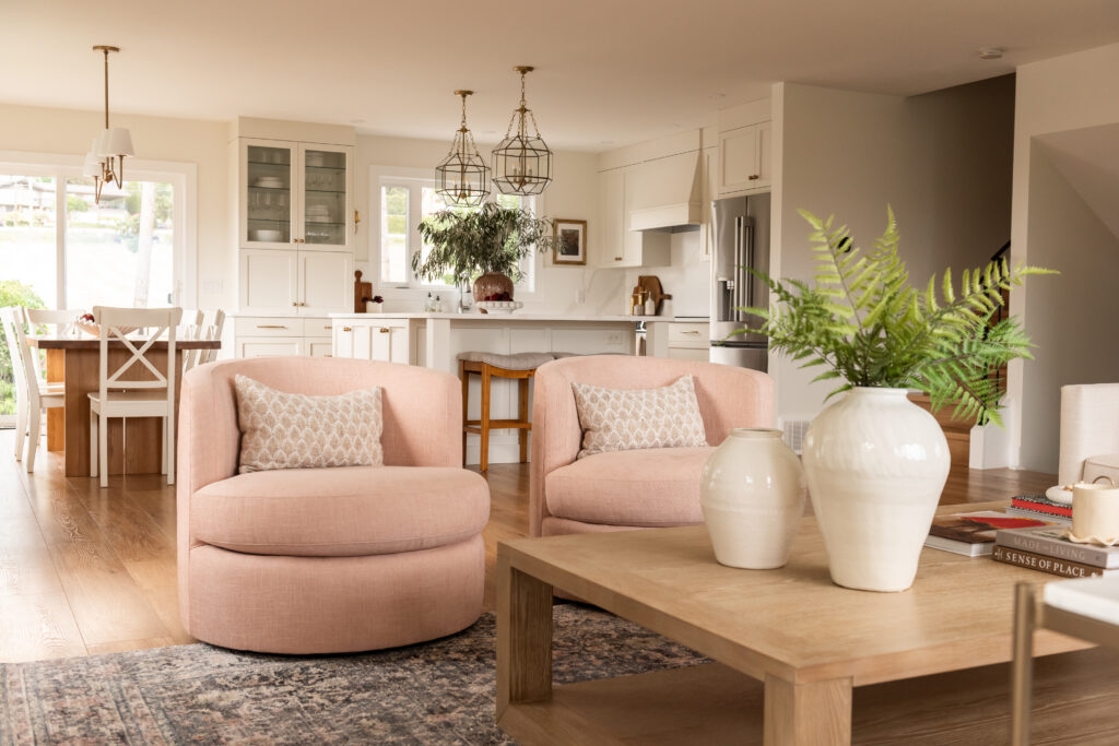 pink living room, swivel chairs, cream kitchen
