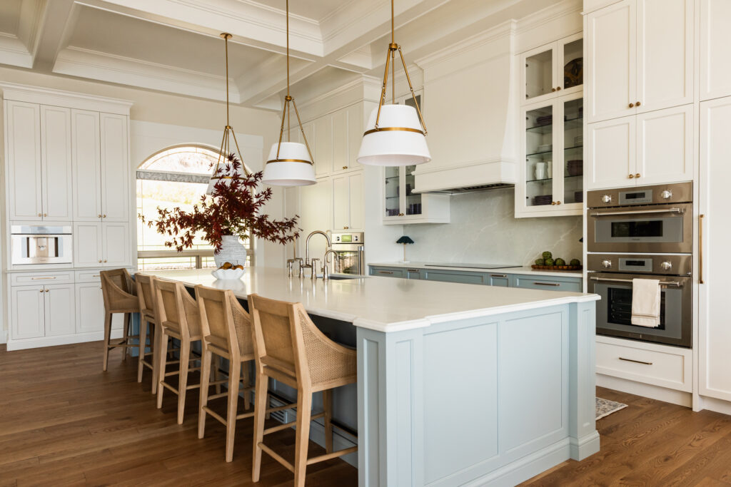 Custom 6-foot range hood feature wall with integrated Thermador appliances, coffered ceilings, polished nickel bridge faucet and a spacious entertaining island.