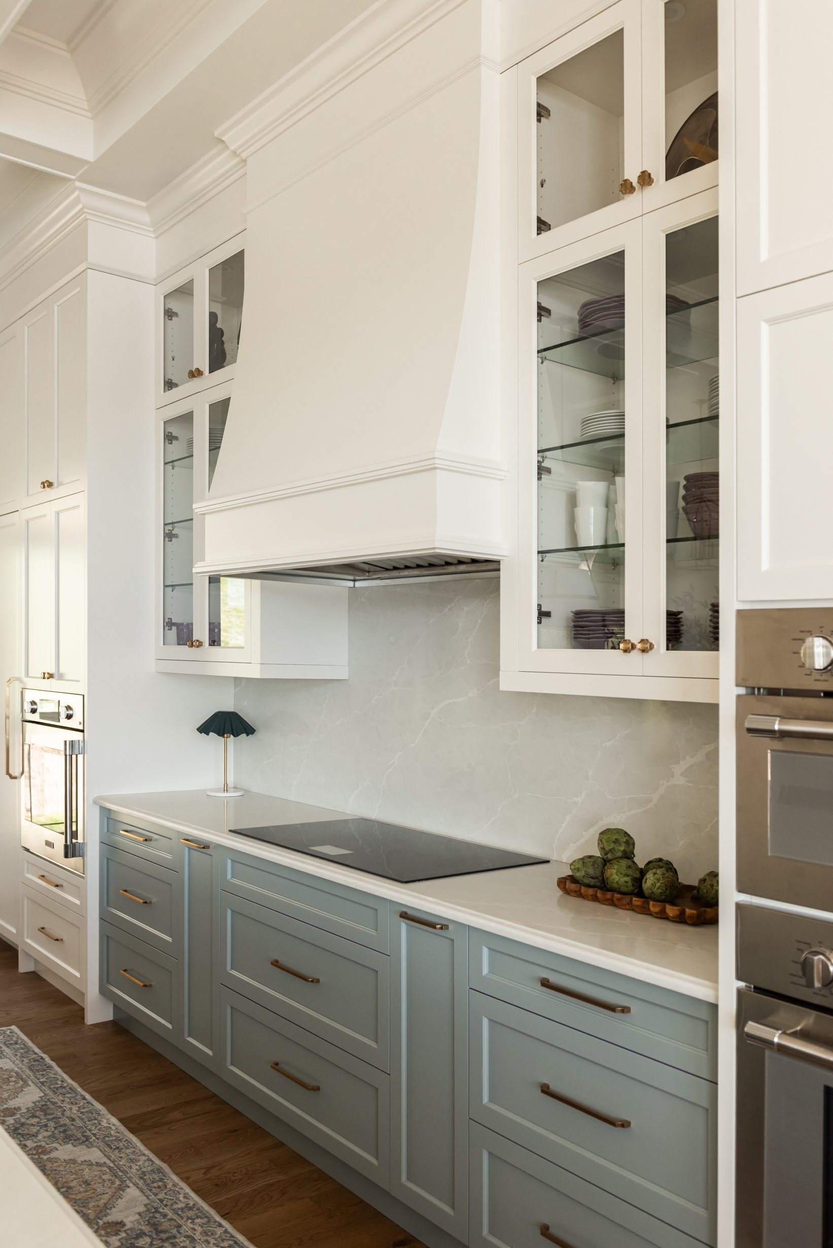 Custom 6-foot range hood feature wall with integrated Thermador appliances, coffered ceilings, polished nickel bridge faucet and a spacious entertaining island.