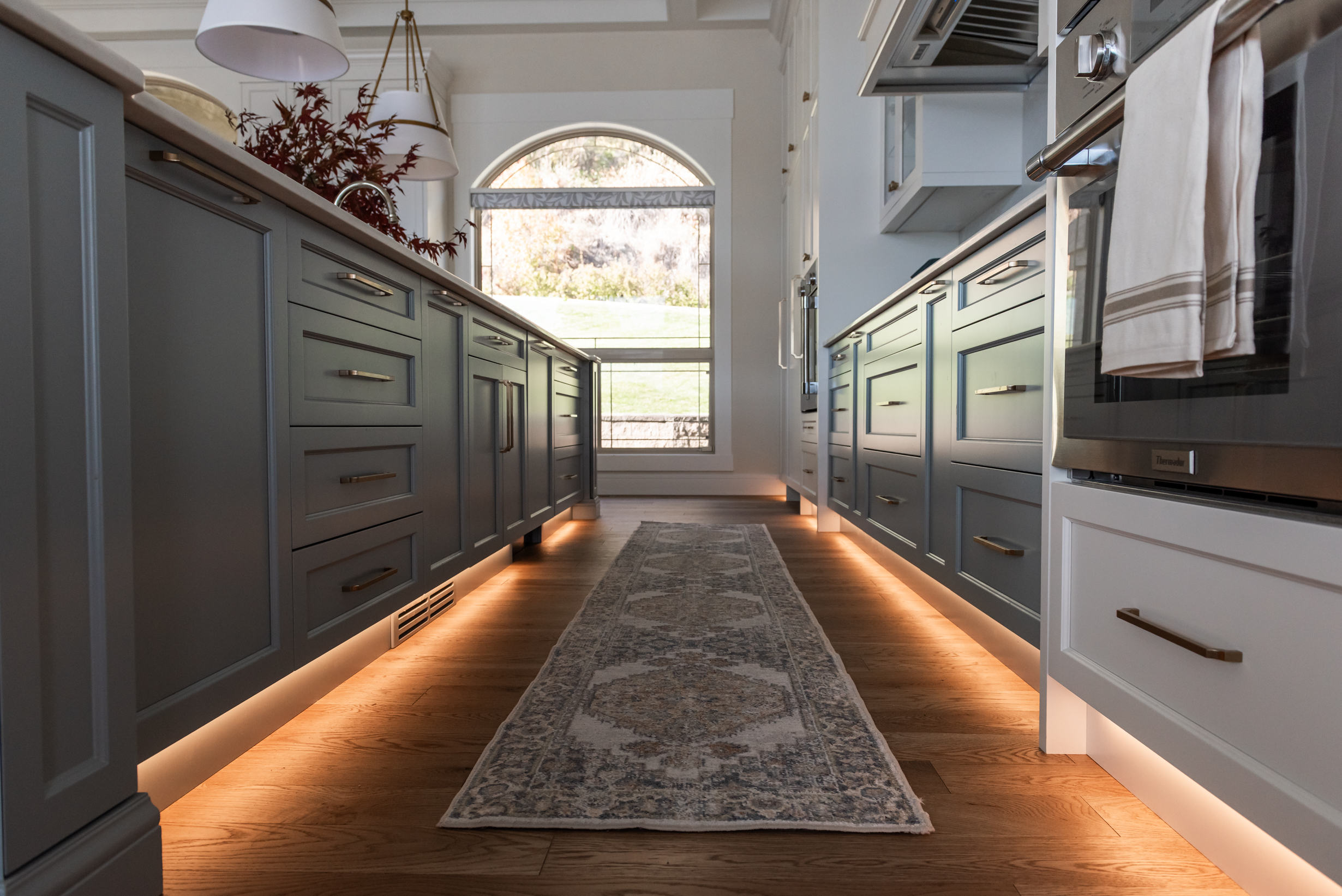 Toe Kick lighting in kitchen with accent french blue cabinetry and integrated Thermador appliances