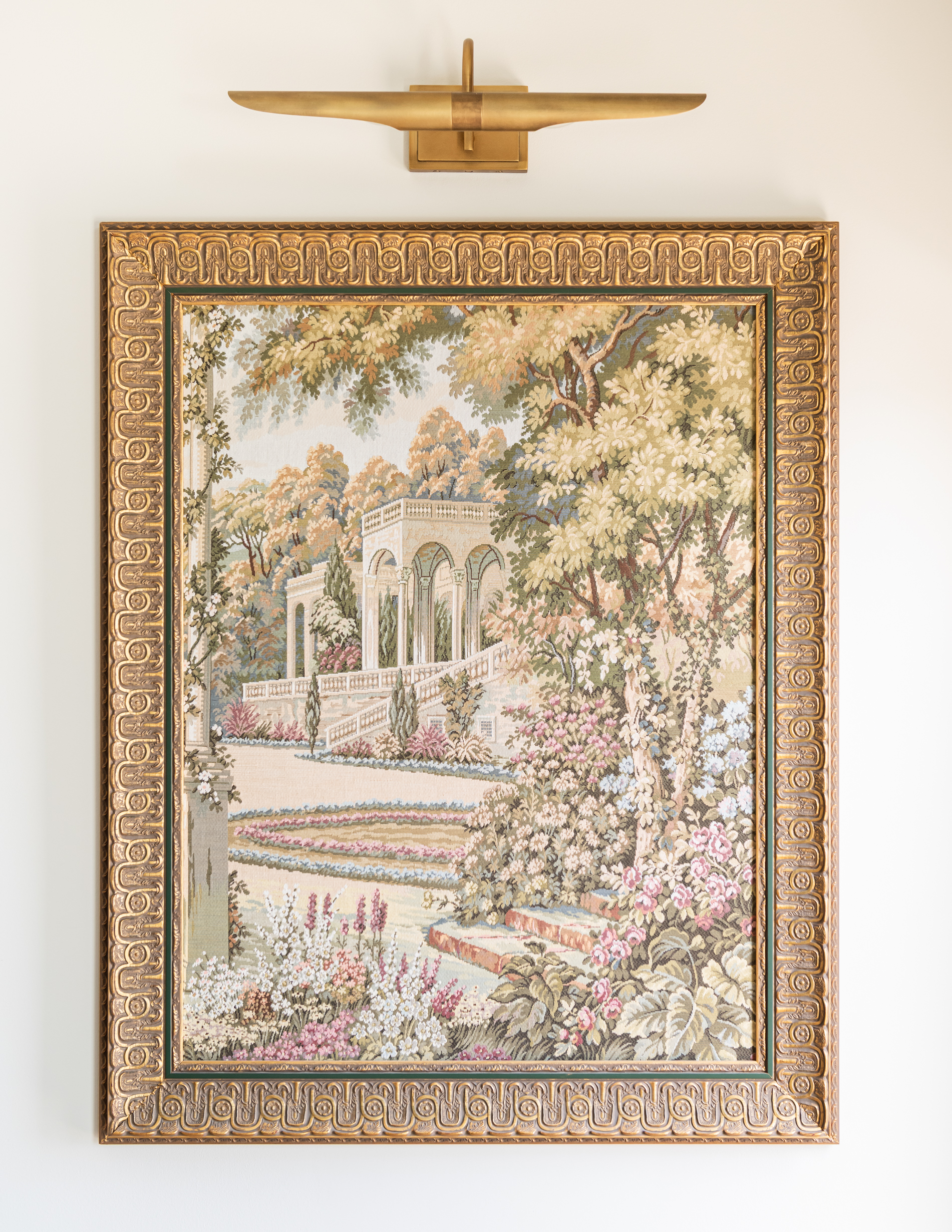 tapestry artwork in antique frame with gold art light