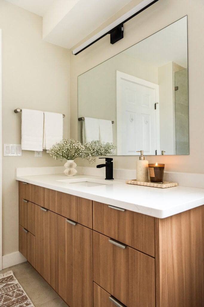 Ensuite bathroom featuring large tiled walk in shower with built in bench, oversized niche, and rainfall shower head.