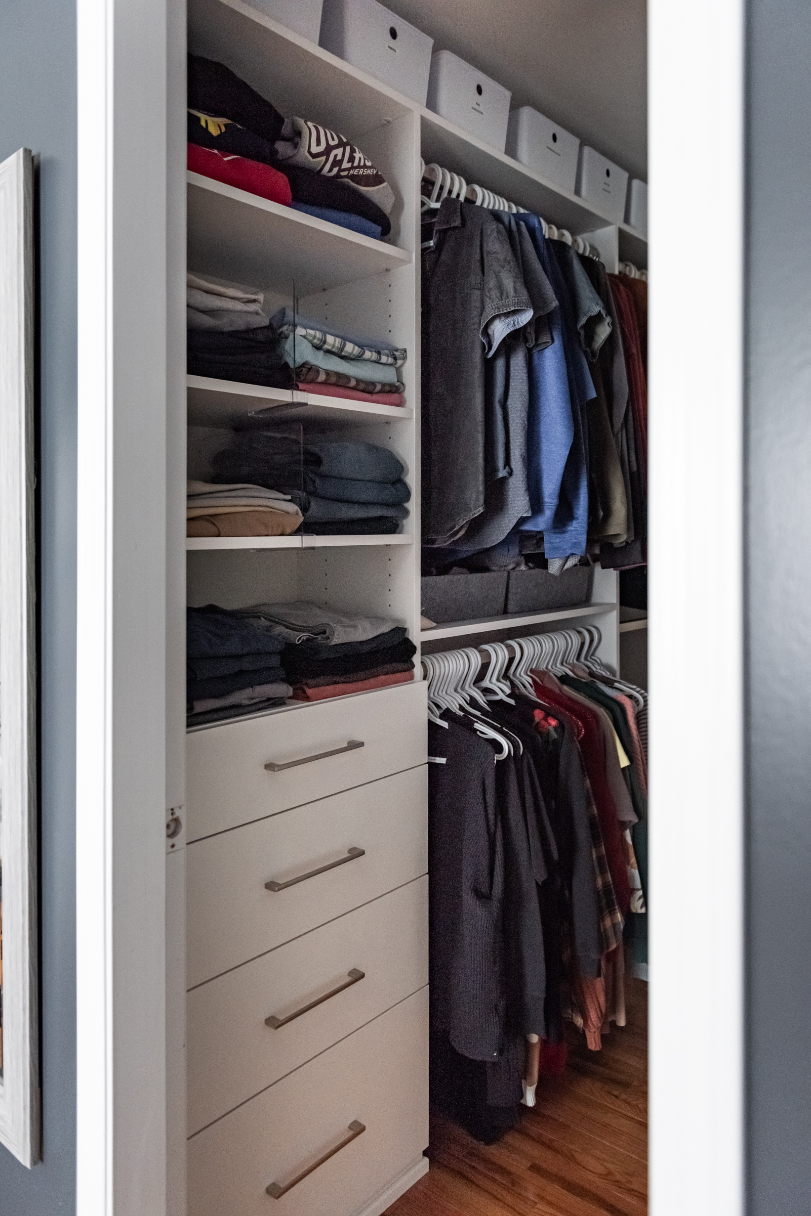 Custom walk in closet with built in storage zones for hanging clothes, folded items, and accessories.
