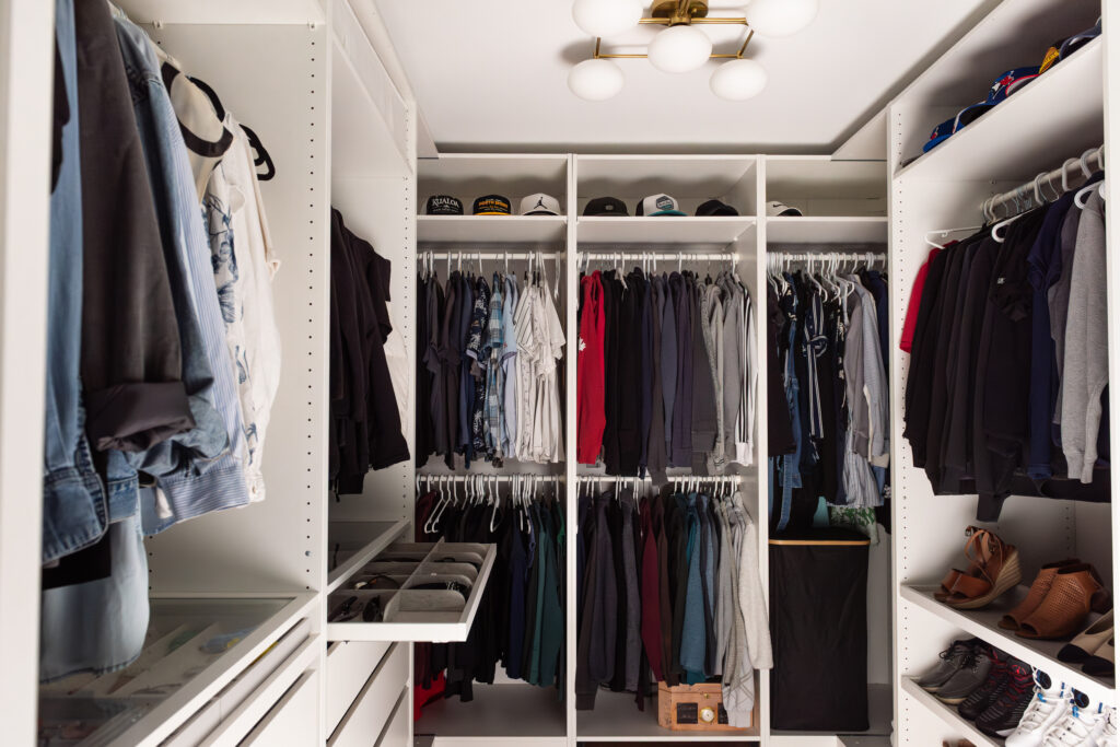 Walk-in closet with custom shelving, organized clothing storage, and built-in drawers