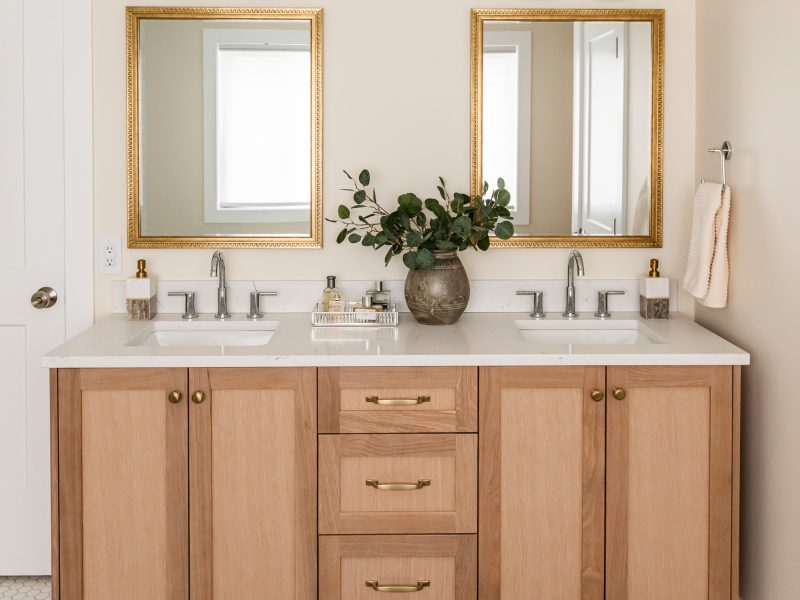transitional ensuite with white oak vanity, vintage mirrors and styling