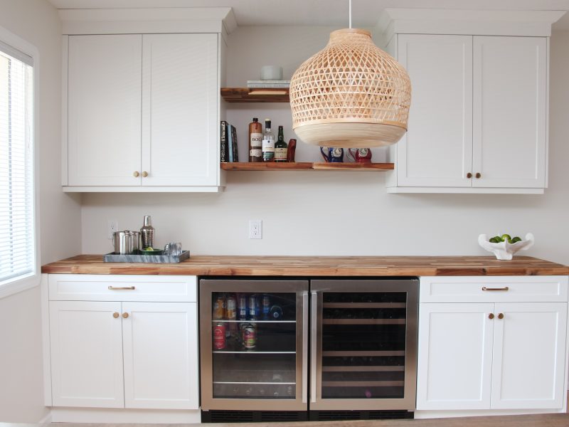 bar in dining room, white cabinets, butcher block countertop, floating wood shelves