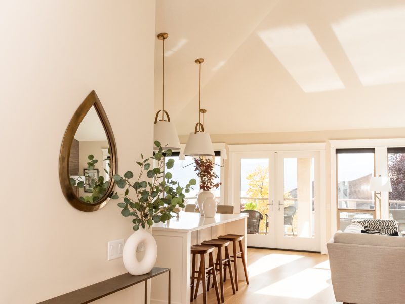 Entry with tall ceilings leading into open concept kitchen living, warm white