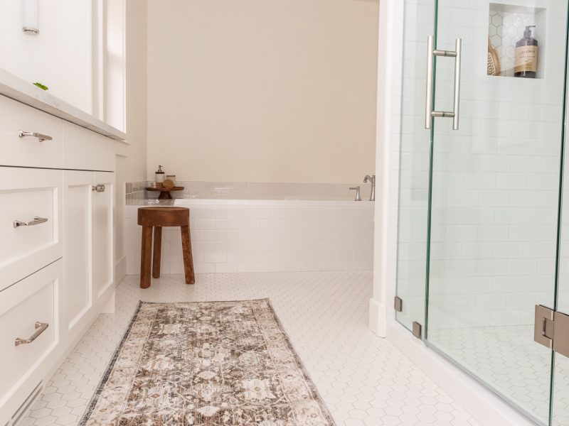 Warm white bathroom with rug and stool