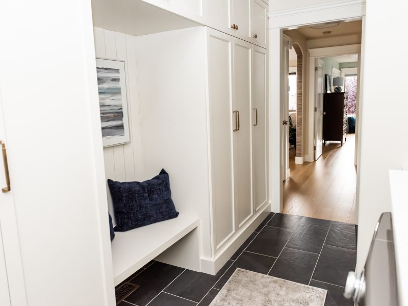Cream mudroom cabinetry shiplap seating nook
