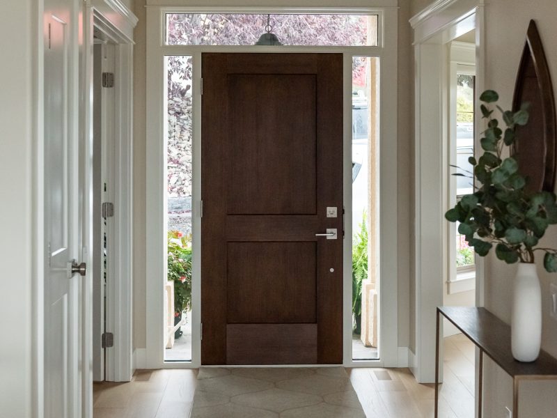 Transitional Entryway with medium wood stain door and transom window